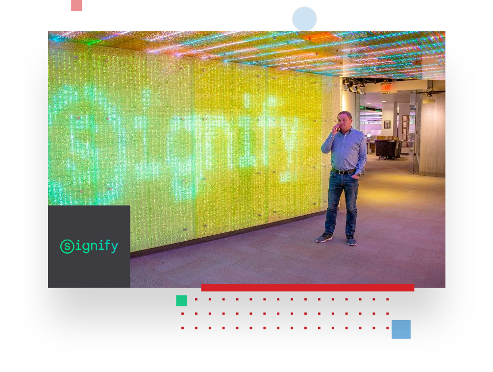 picture of a Signify employee in front of a wall full of LED lights, displaying the succesverhalen