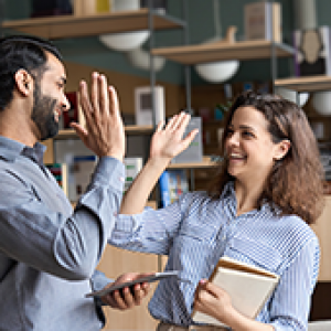 Two happy and friendly professionals, teacher and student, the five high positions in office celebrate success, good cooperation result, partnership teamwork and team motivation in office work.